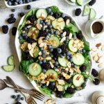 A large platter of spinach blueberry salad.