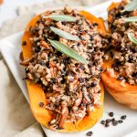 A half butternut squash stuffed with wild rice, on a platter.