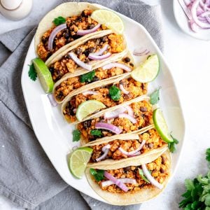 A tray lined with vegan tempeh tinga tacos.