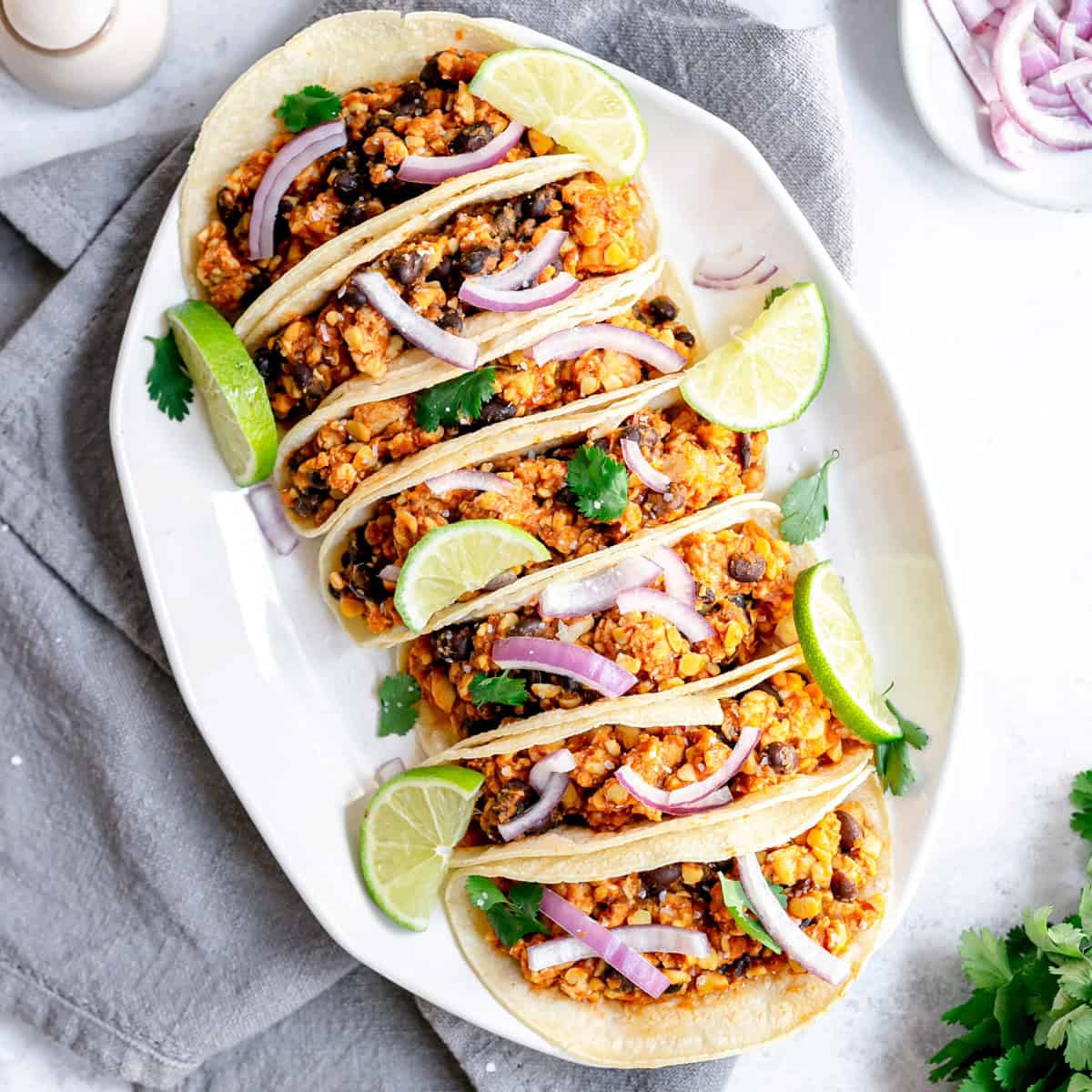 A tray lined with vegan tempeh tinga tacos.
