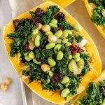 A tray of spaghetti squash boats stuffed with edamame, kale, cherries, and hazelnuts.