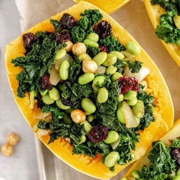 A tray of spaghetti squash boats stuffed with edamame, kale, cherries, and hazelnuts.
