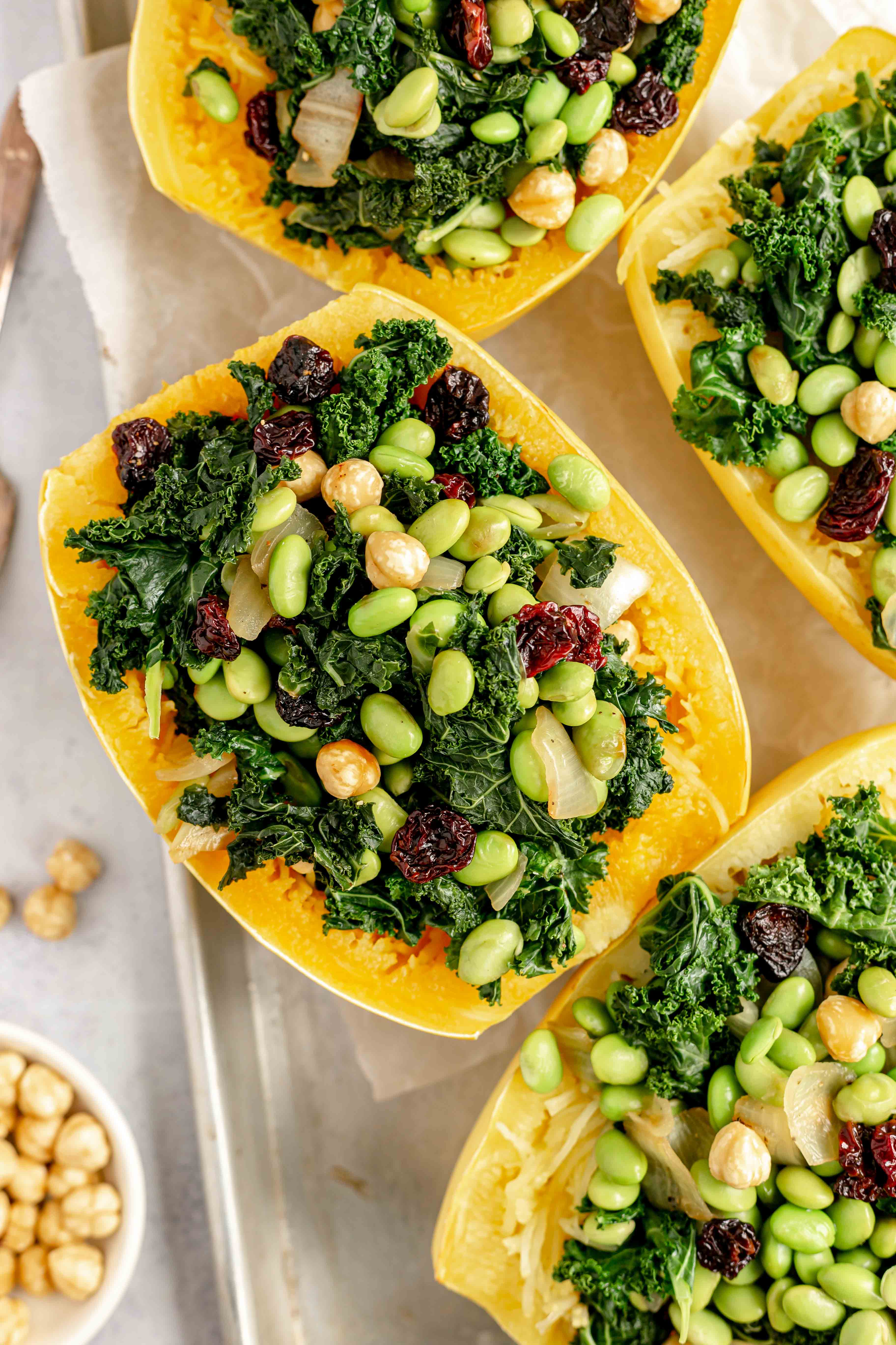 A tray of spaghetti squash boats stuffed with edamame, kale, cherries, and hazelnuts.