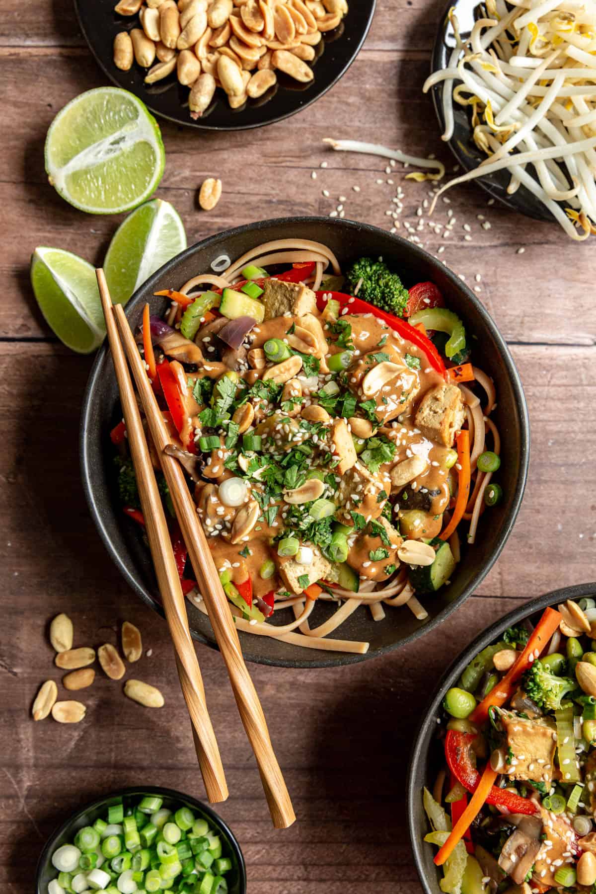 A bowl of vegan Oil-Free Pad Thai with peanuts, bean sprouts, and lime juice on the side.