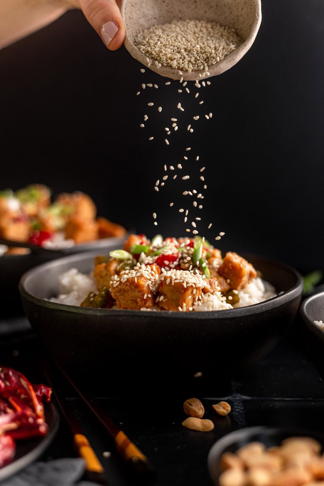 Kung Pao Tempeh adding sesame seeds