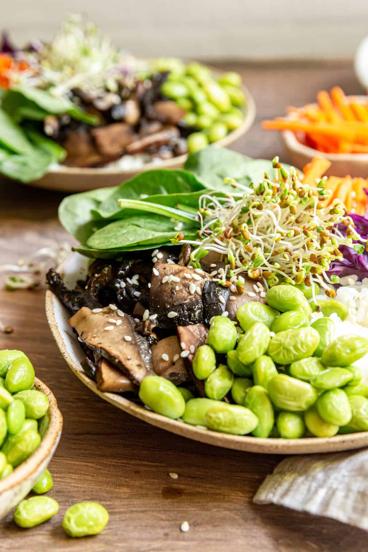 Close up of the mushrooms and edamame in a poke bowl.