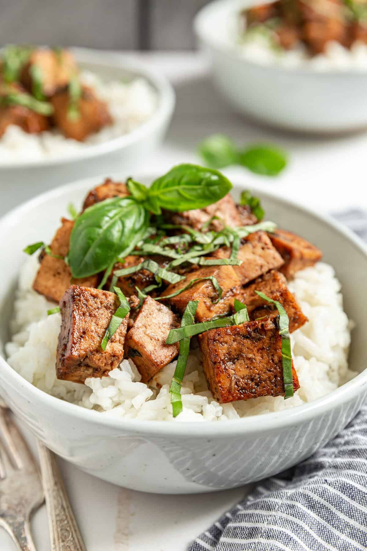 A bowl of Basil Balsamic Marinated Tofu with a garnish of fresh basil.