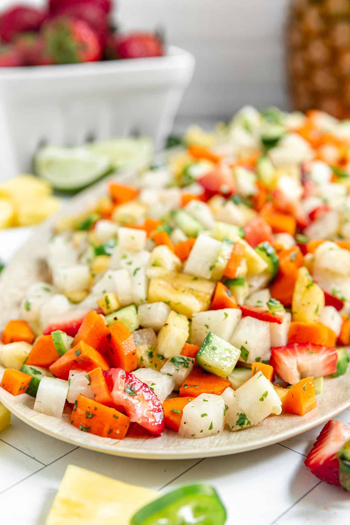 A platter of Jicama Pineapple Slaw served with extra strawberries and pineapple.