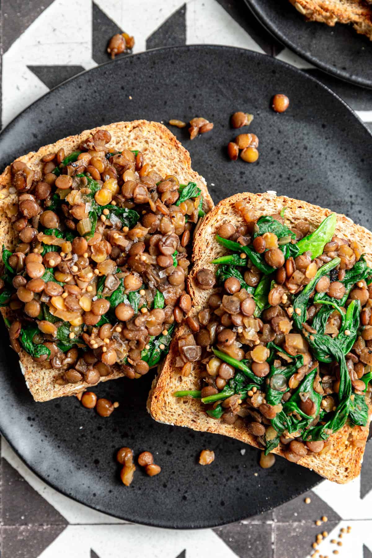 Lentils and Greens Toast plated with a garnish of mustard seed.