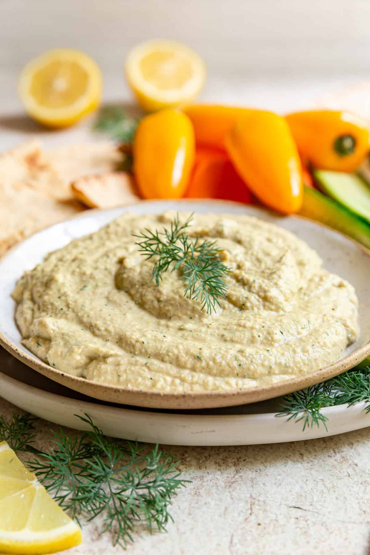 A bowl of Lemon Dill Hummus with a garnish of dill.