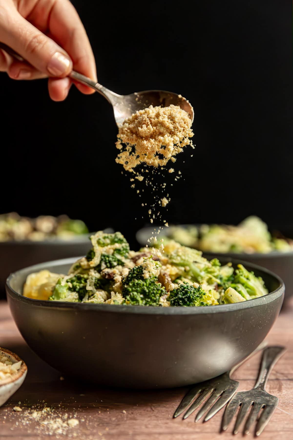 Vegan parmesan sprinkled onto a bowl of broccoli parmesan spaghetti squash.