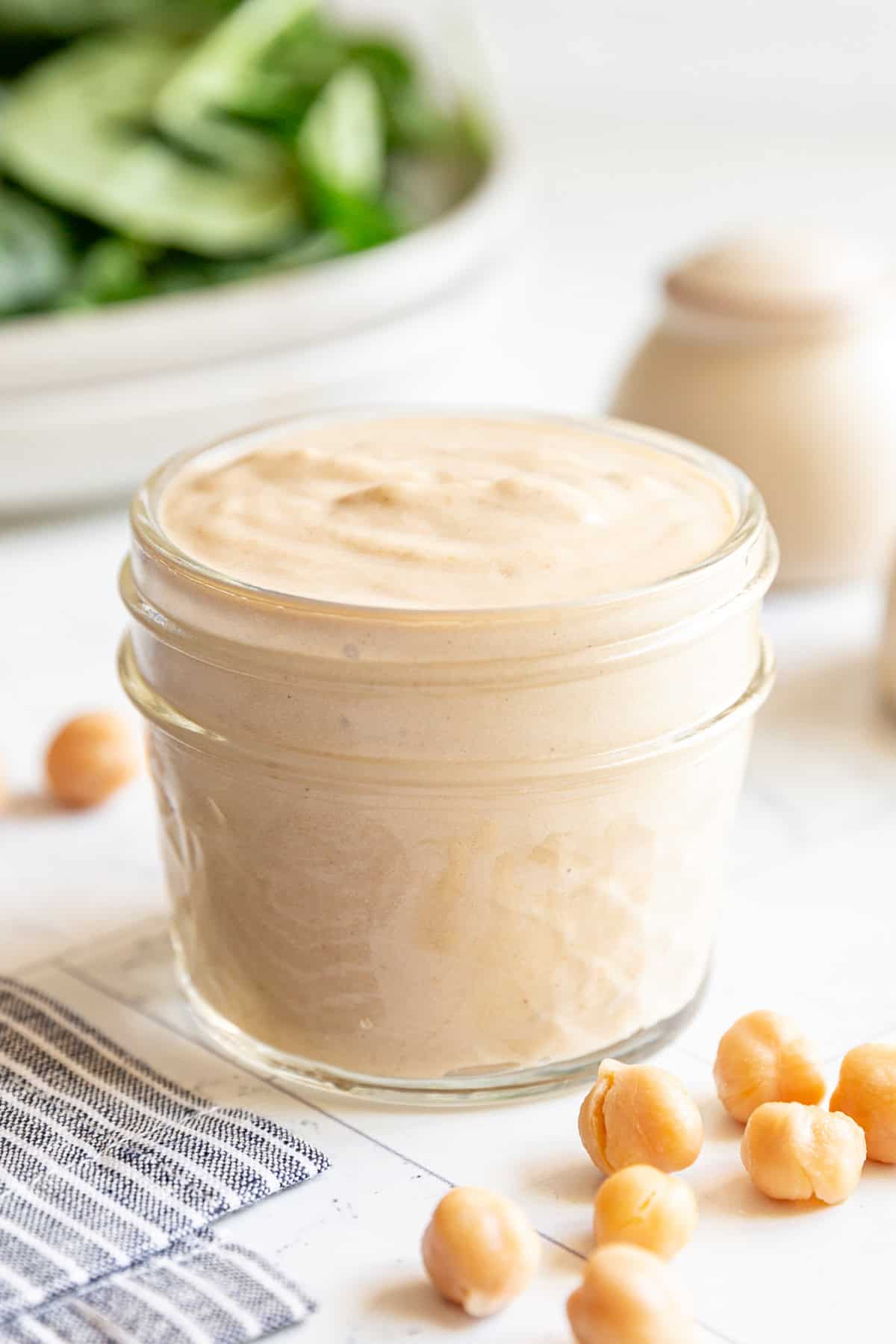 A mason jar filled with Vegan Chickpea Dressing.