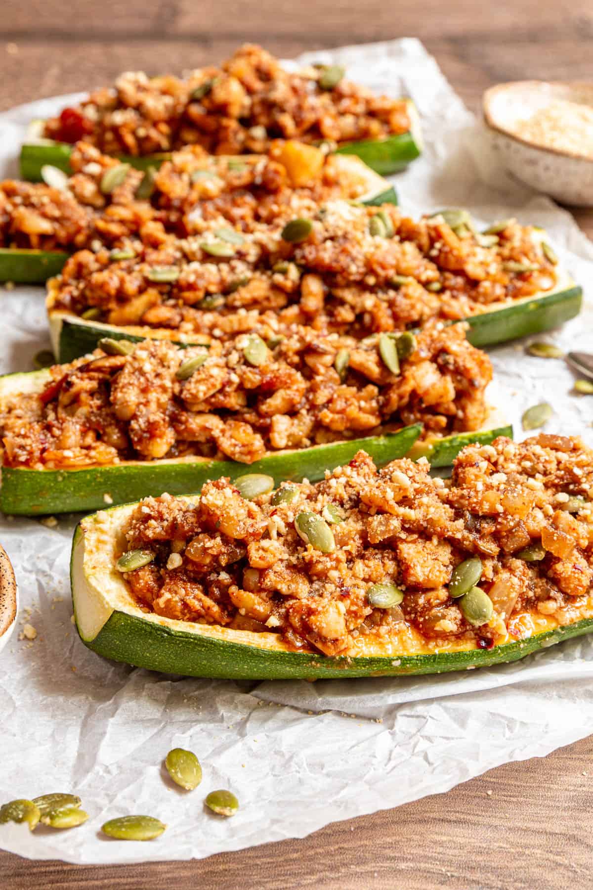 A line of Vegan Zucchini Boats on a sheet of parchment paper.