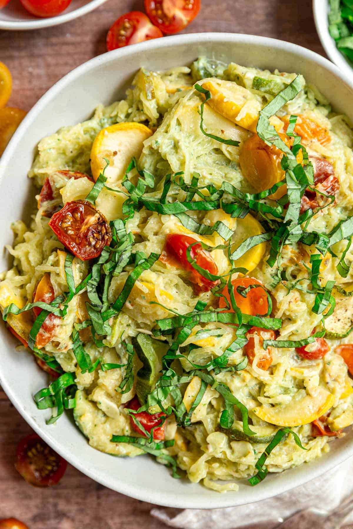 A large bowl of Creamy Vegan Pesto Spaghetti Squash with Roasted Tomatoes & Zucchini.