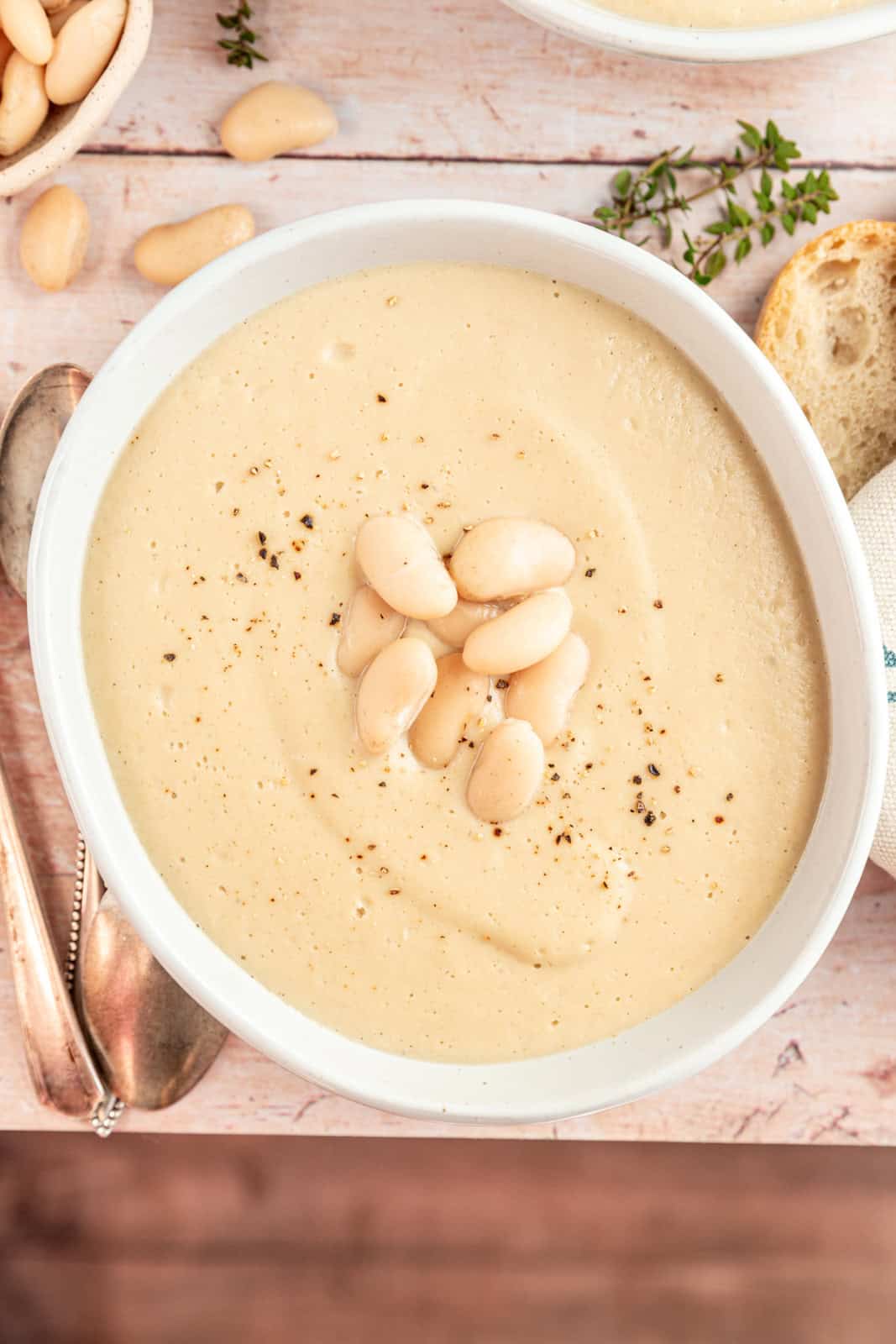 A bowl of Creamy Cauliflower White Bean Soup on a table.