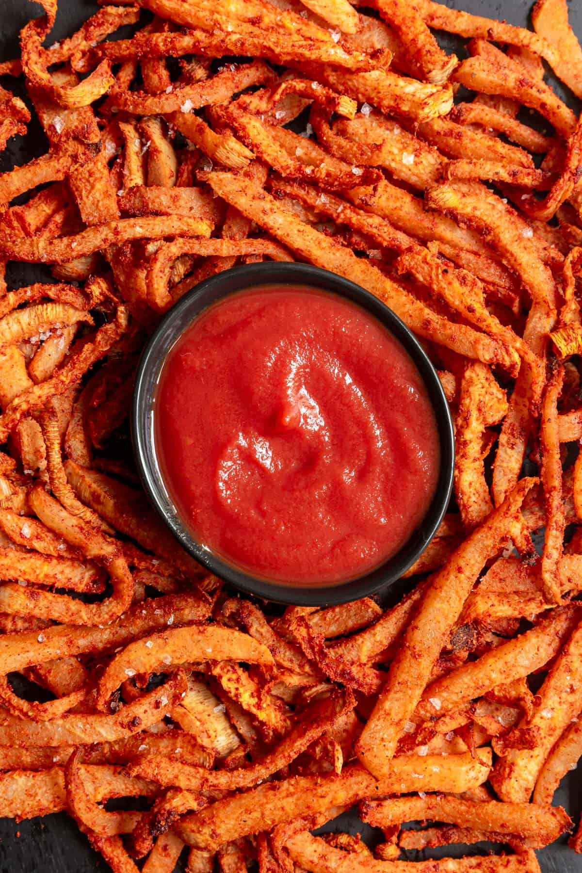 Jicama air fryer fries with a bowl of ketchup.