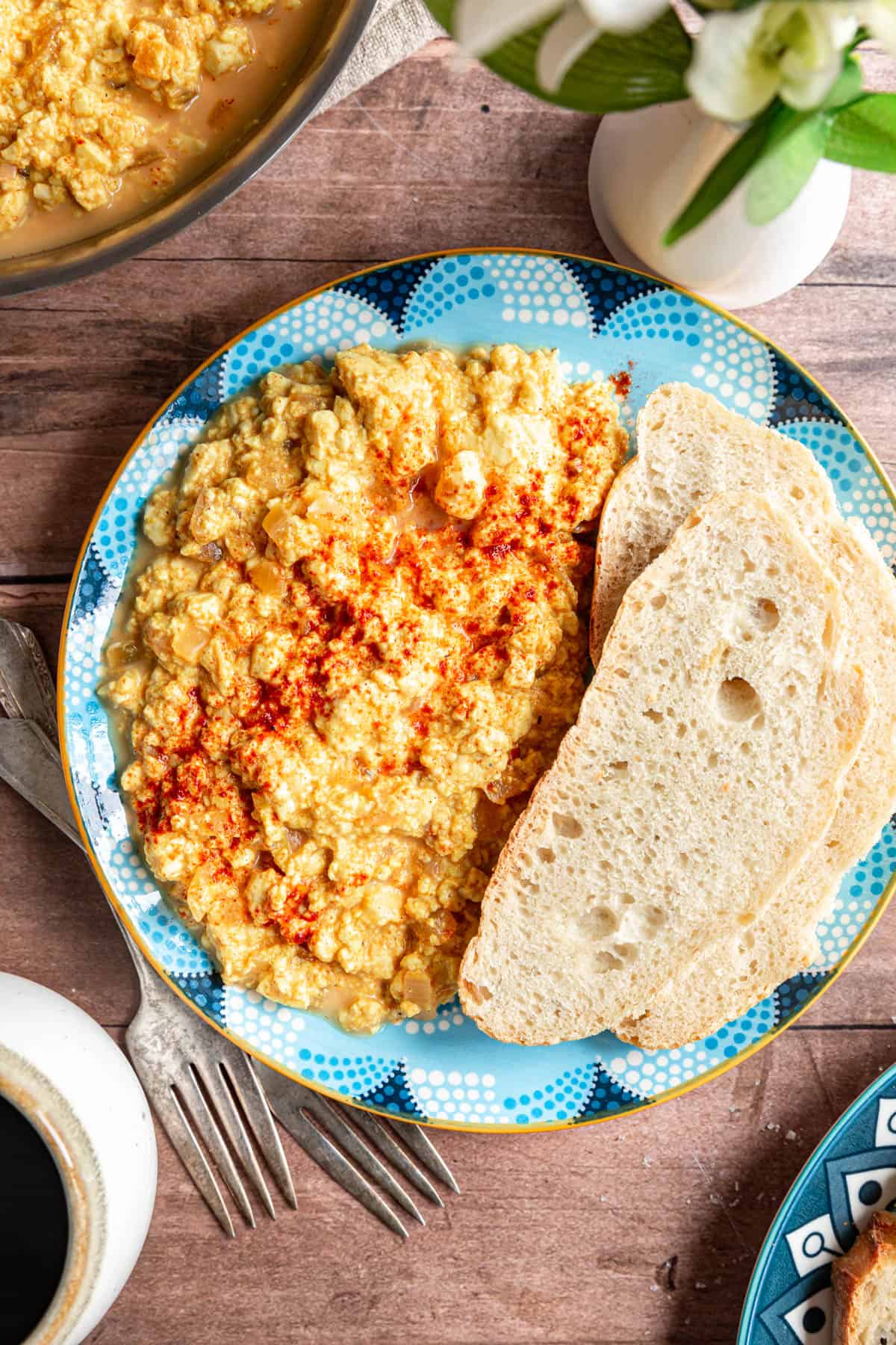 A plate of Silken Tofu Scrambled Eggs set out for breakfast with coffee and toast.