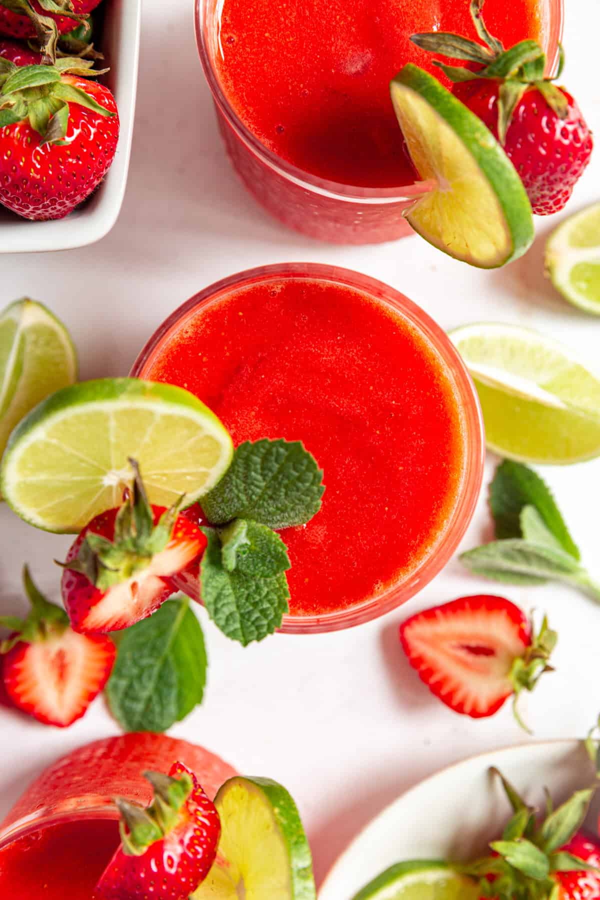 A top-down view of three Strawberry Daiquiri Mocktail glasses.
