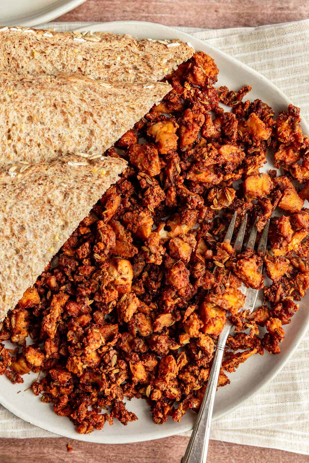 A plate of Tofu Breakfast Sausage Crumbles with a napkin and fork.