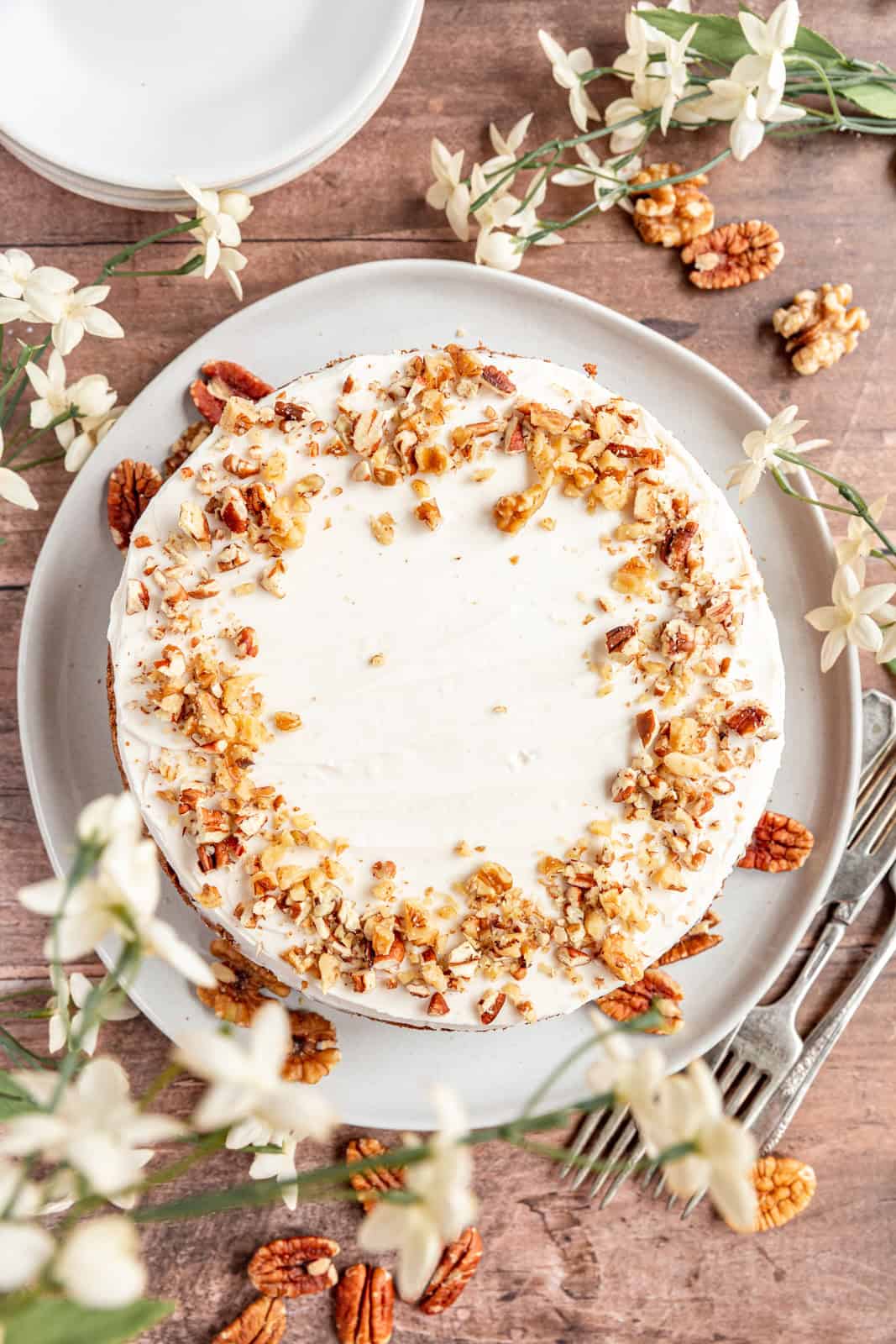 Top down view of Vegan Oil-Free Carrot Cake, frosted and decorated with nuts.