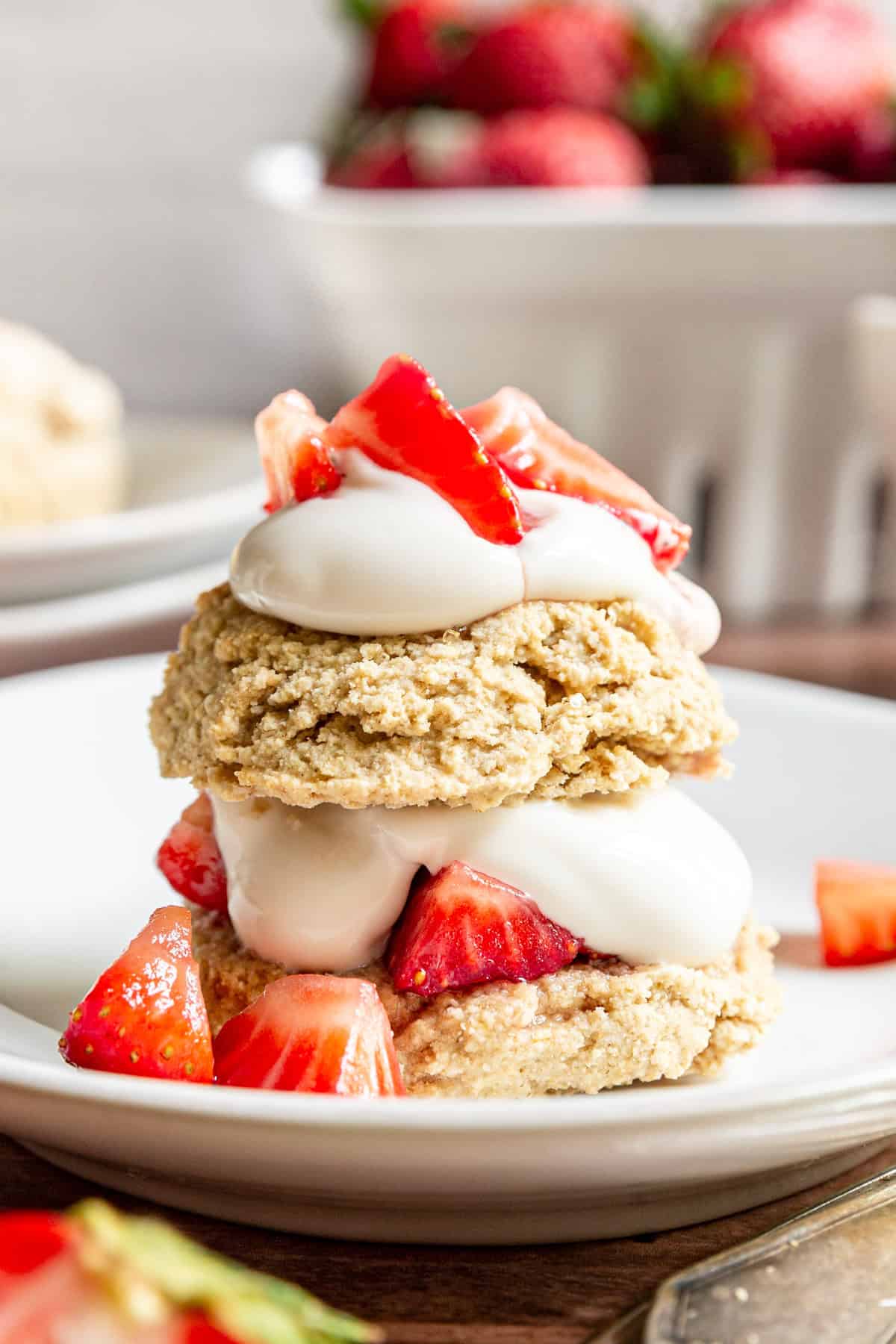 A Gluten-Free Vegan Strawberry Shortcake with strawberries and cream inside and on top of the biscuit.