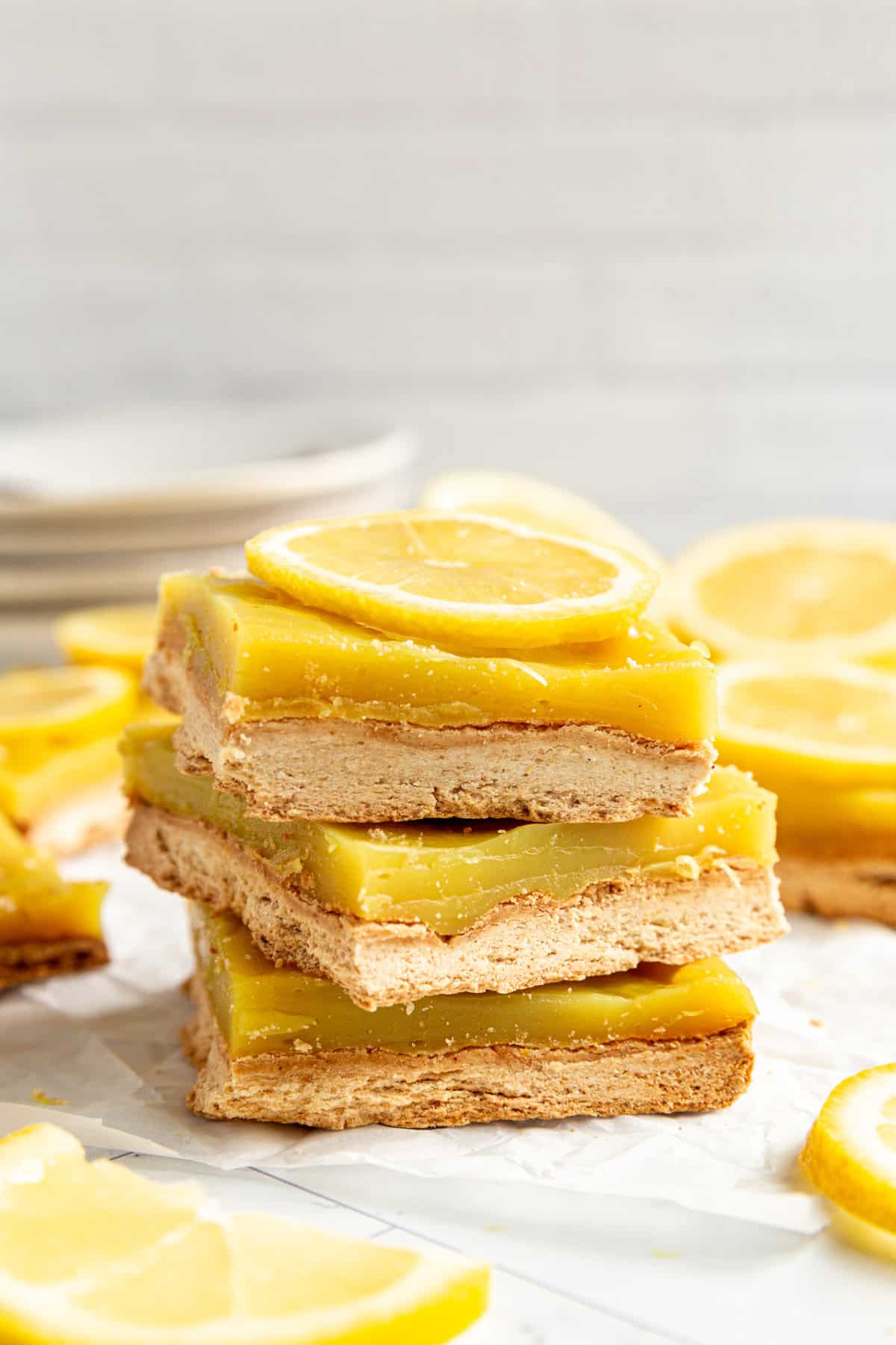 A stack of Plant-Based Lemon Bars on a sheet of parchment.