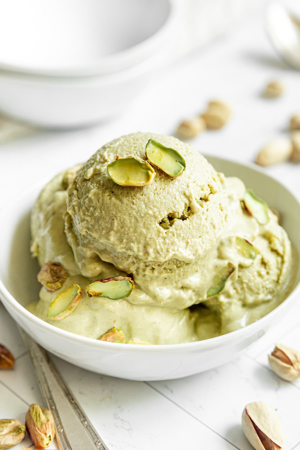 A bowl with several scoops of Vegan Pistachio Ice Cream.