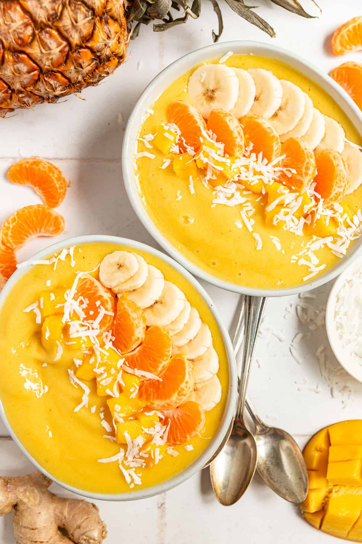 Two smoothie bowls decorated with fresh fruit.