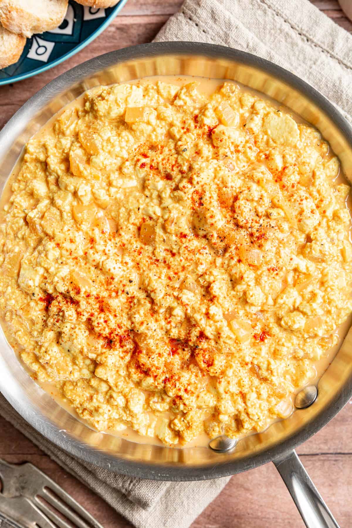 A pan of freshly cooked Silken Tofu Scrambled Eggs sprinkled with paprika.