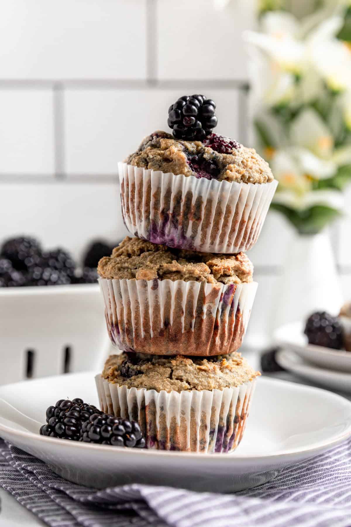 Vegan Blackberry Muffins stacked on a plate.