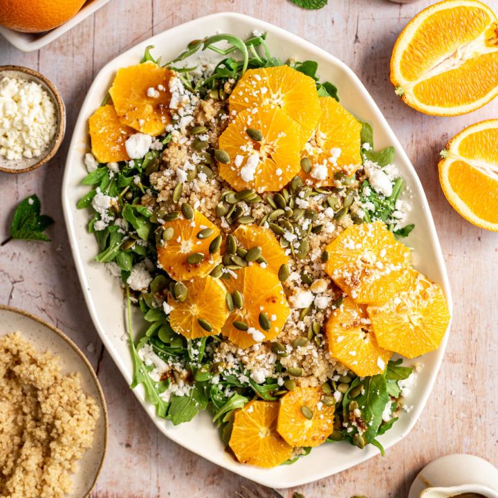 A platter of arugula citrus salad, with fresh oranges and extra quinoa.