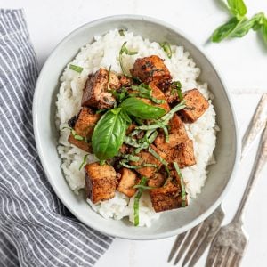 A bowl of basil balsamic marinated tofu, served over rice.