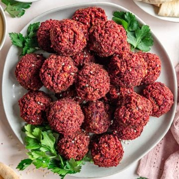 A plate of beetroot falafel, served with parsley.