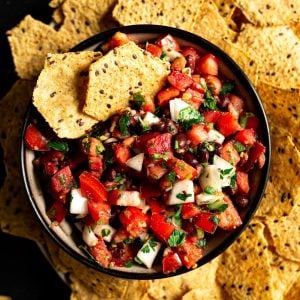A bowl of black bean pico de gallo served with tortilla chips.