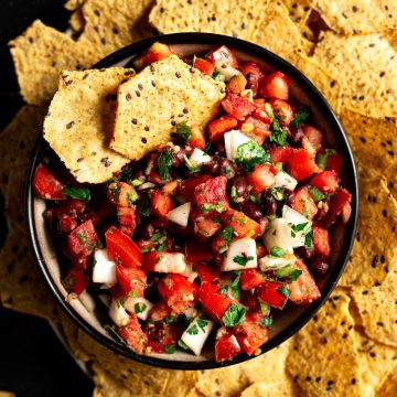 A bowl of black bean pico de gallo served with tortilla chips.