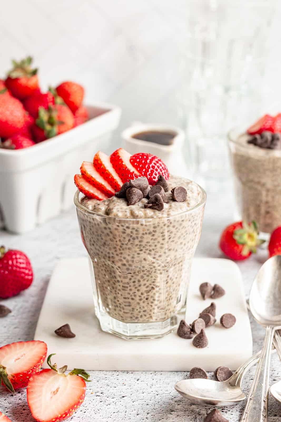 A jar filled with chia pudding, topped with strawberries and chocolate chips.