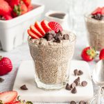 A jar filled with chia pudding, topped with strawberries and chocolate chips.