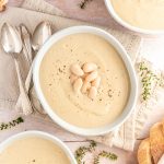 Three bowls of creamy cauliflower white bean soup.