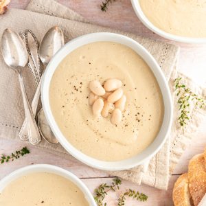 Three bowls of creamy cauliflower white bean soup.