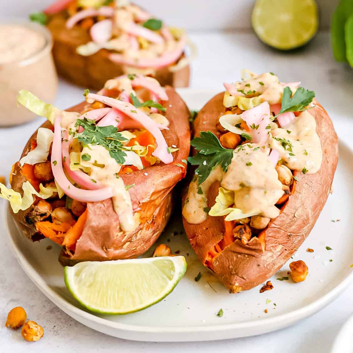 Two crispy chickpea stuffed sweet potatoes on a plate.