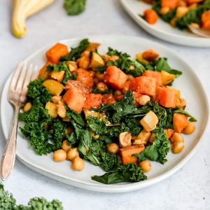A plate of fall veggie sweet potato hash with a fork, ready to eat.