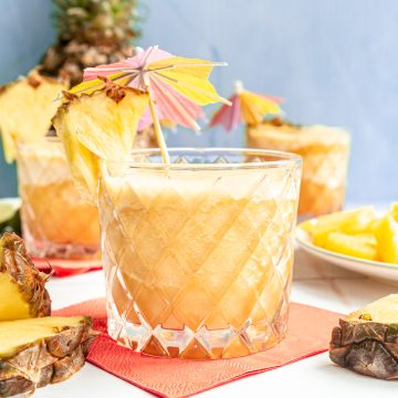 A glass of piña colada mocktail, garnished with an umbrella.