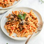 A plate of gemelli with tomato sauce, garnished with parsley, ready to eat.