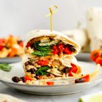 A breakfast burrito sliced in half.