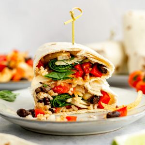 A breakfast burrito sliced in half.