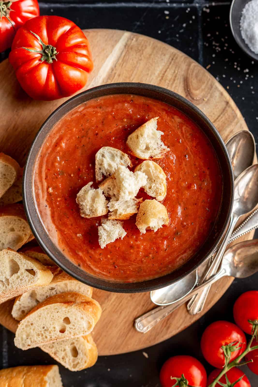 A bowl of roasted tomato soup, topped with croutons.