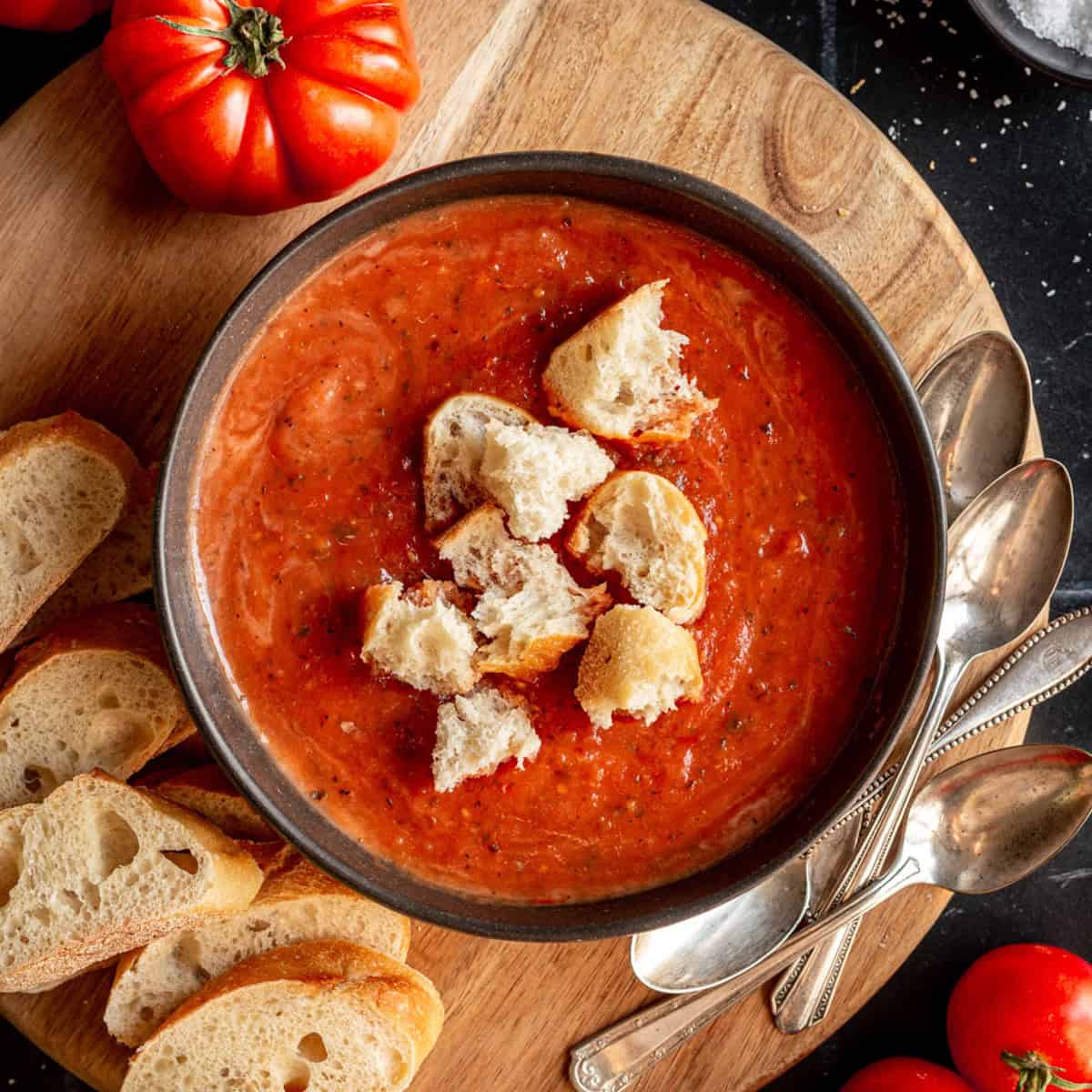 A bowl of roasted tomato soup, topped with croutons.