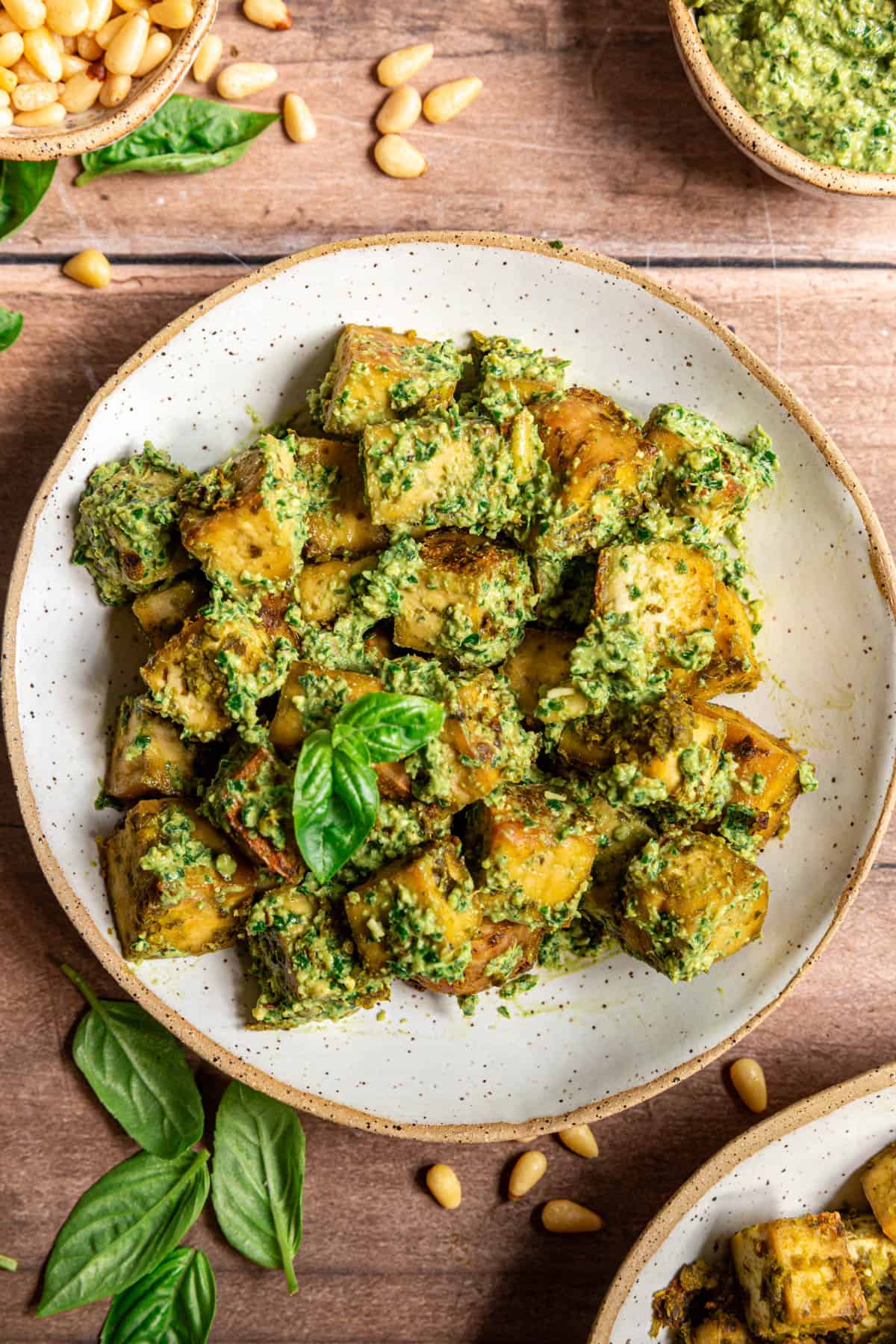 A bowl of pesto tofu, tossed with pesto.