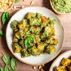 A bowl of pesto tofu, tossed with pesto.