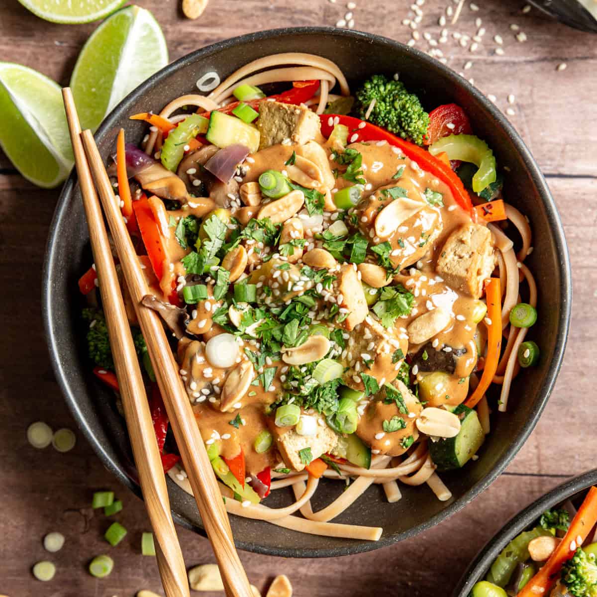 A bowl of plant-based pad thai with chopsticks.